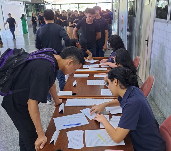 Foto mostra grupo de pessoas recebendo informações
