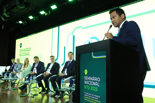 Homem falando no microfone em evento sobre transporte urbano