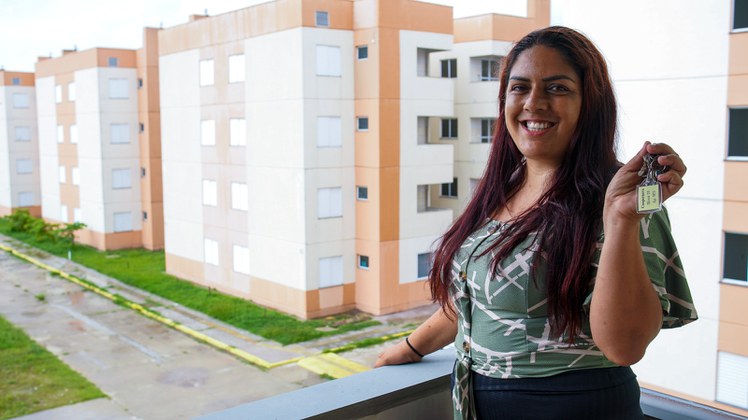 Na imagem mulher com chave da cassa própria 